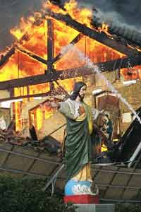 阪神淡路大震災発生当時のカトリックたかとり教会（神戸市長田区）。キリスト像の背後にある教会が燃えている。